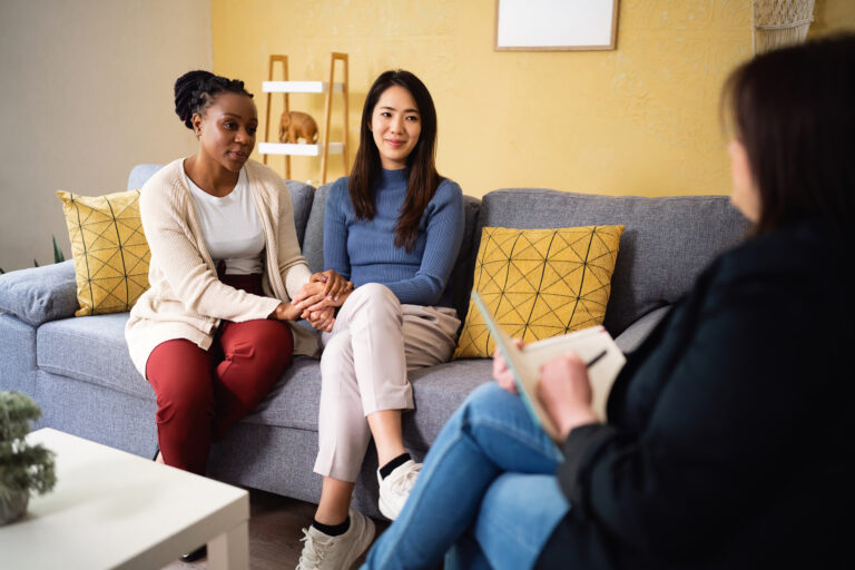 Multiracial lesbian couple having a couple therapy, led by the female Caucasian psychotherapist