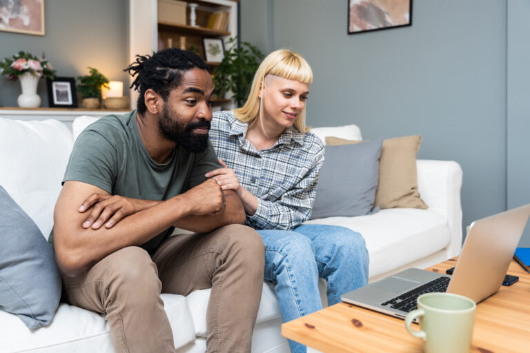Young man and woman, happy couple, talking to friendly psychologist while making video call to clinic from home. Relationship difficulties solving with online psychotherapy with psychologist.